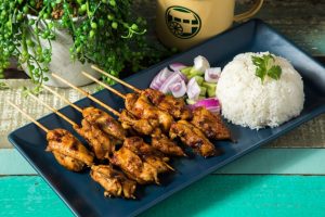 Marinated and grilled chicken skewers served with peanut sauce, cucumbers and red onions.