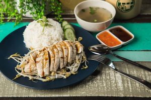 The famous Hainanese chicken rice (boneless) served with fragrant ginger garlic rice, bean sprout, soy sauce and homemade chili sauce
