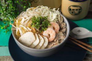 Clear chicken soup with vermicelli, prawn, fish cake, shredded chicken, bean sprouts and cabbage.